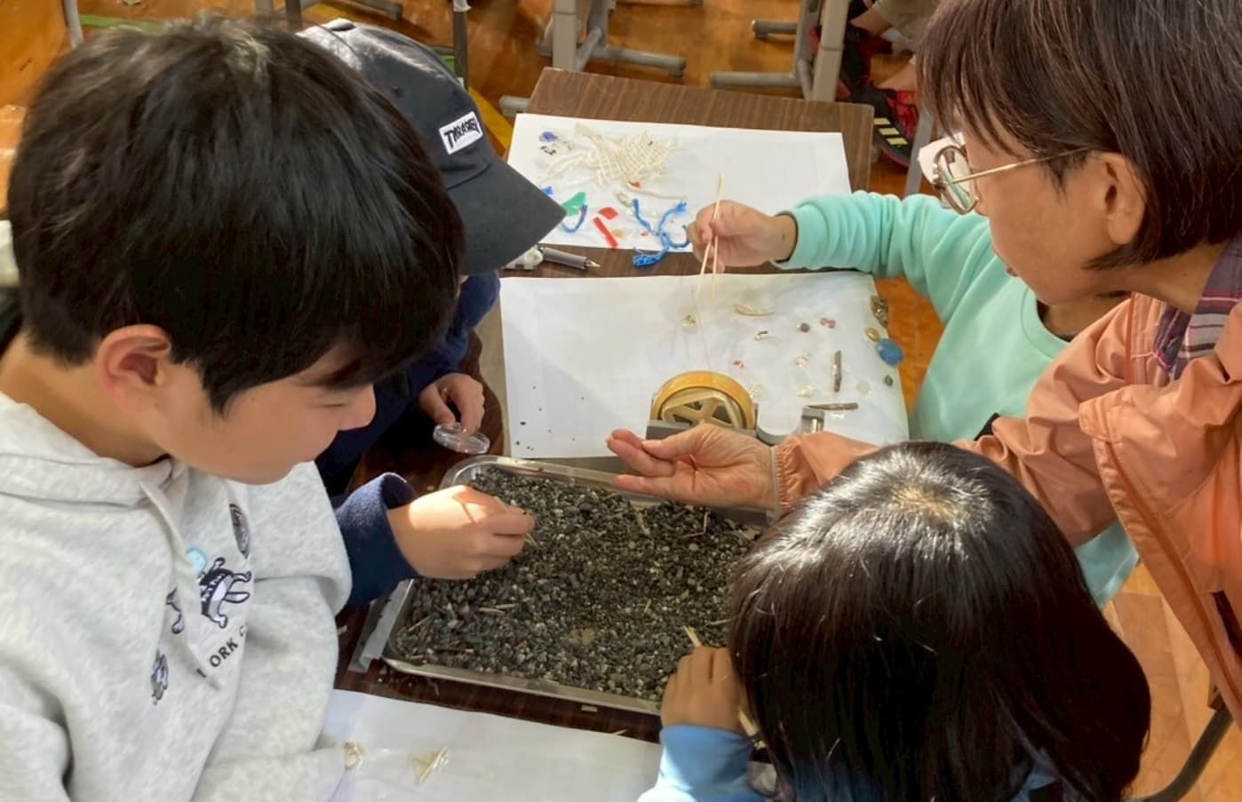 砂の中からマイクロプラスチックを探す様子